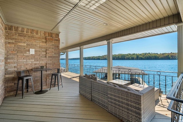 view of dock with an outdoor living space, a water view, and outdoor dry bar