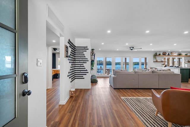 living area with ceiling fan, stairway, dark wood finished floors, and recessed lighting