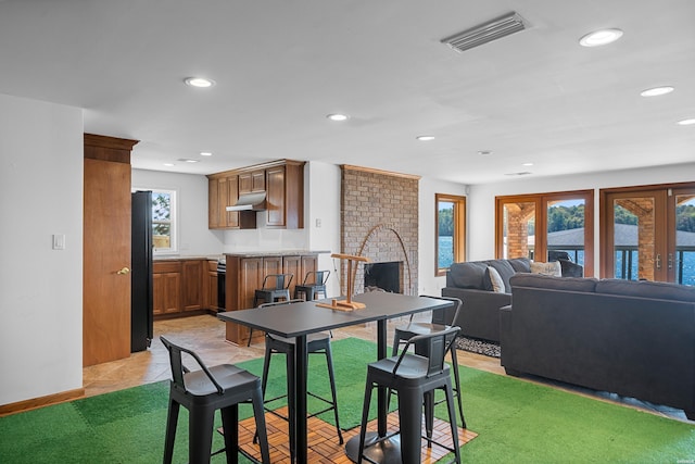 dining area featuring light tile patterned floors, baseboards, visible vents, a fireplace, and recessed lighting