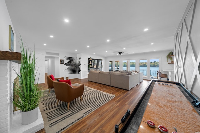 living room with dark wood-type flooring, recessed lighting, and stairs