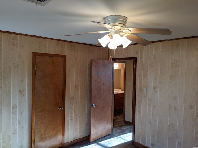 spare room featuring visible vents, ceiling fan, and wooden walls