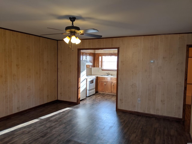 unfurnished room with a sink, dark wood finished floors, and baseboards