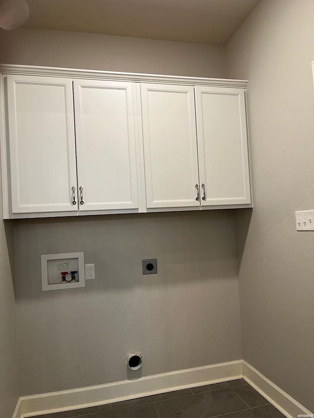 laundry room featuring hookup for a washing machine, dark tile patterned flooring, baseboards, cabinet space, and electric dryer hookup