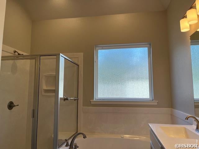 bathroom featuring a stall shower, vanity, and a bath