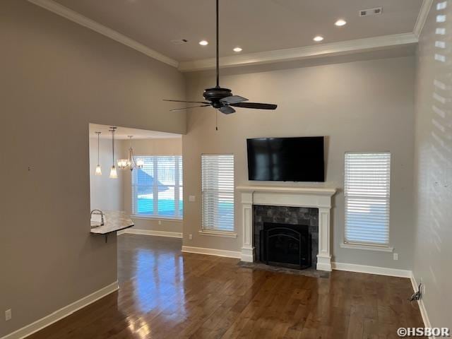 unfurnished living room featuring a fireplace with flush hearth, visible vents, ornamental molding, and dark wood-style flooring