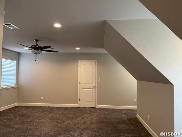 bonus room with baseboards, visible vents, and dark colored carpet