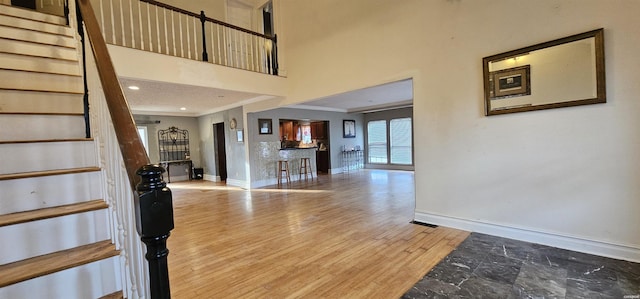 foyer with baseboards, stairway, and wood finished floors