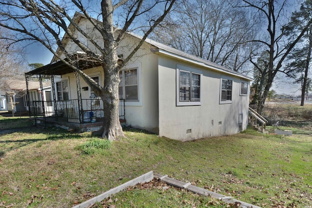 exterior space featuring stucco siding, a porch, a lawn, and crawl space