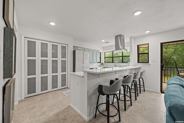 5371 Central Ave Unit 3C, Hot Springs, AR 71913 - kitchen with freestanding refrigerator, island range hood, light countertops, a peninsula, and a breakfast bar area