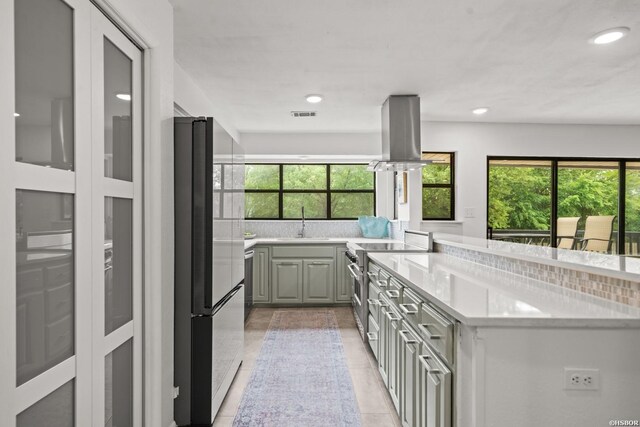 5371 Central Ave Unit 3C, Hot Springs, AR 71913 - kitchen with island exhaust hood, stainless steel stove, freestanding refrigerator, light countertops, and recessed lighting