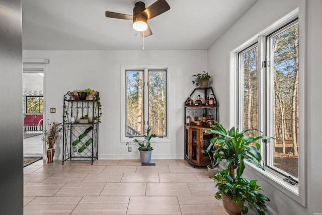 interior space with plenty of natural light, baseboards, and ceiling fan