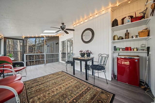 sunroom / solarium with ceiling fan and a skylight