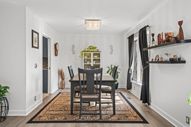 dining space with wood finished floors and baseboards