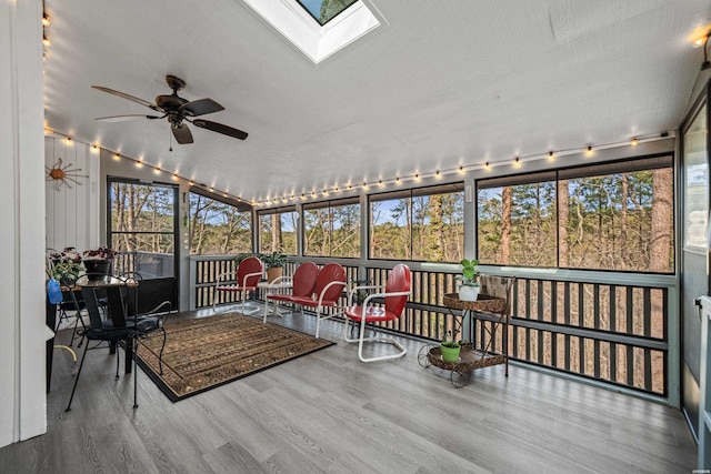 sunroom / solarium featuring vaulted ceiling with skylight and a ceiling fan