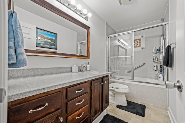 full bath featuring shower / bath combination with glass door, visible vents, toilet, vanity, and tile patterned flooring