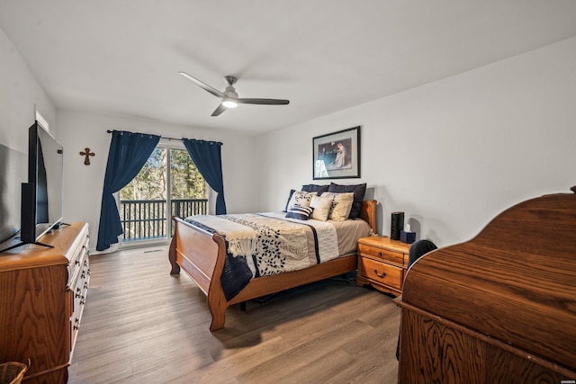 bedroom featuring visible vents, access to outside, wood finished floors, and a ceiling fan