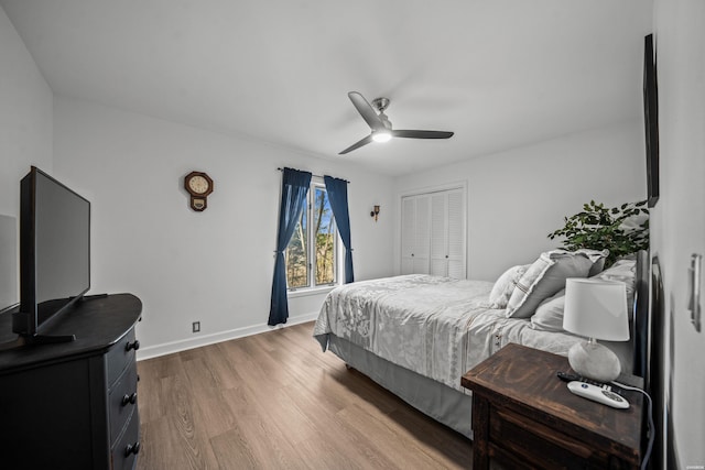 bedroom featuring ceiling fan, a closet, wood finished floors, and baseboards