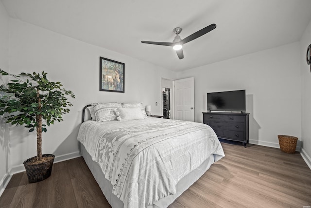 bedroom with a ceiling fan, baseboards, and wood finished floors