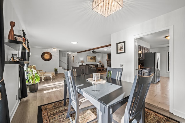 dining space featuring a ceiling fan, baseboards, stairway, and wood finished floors