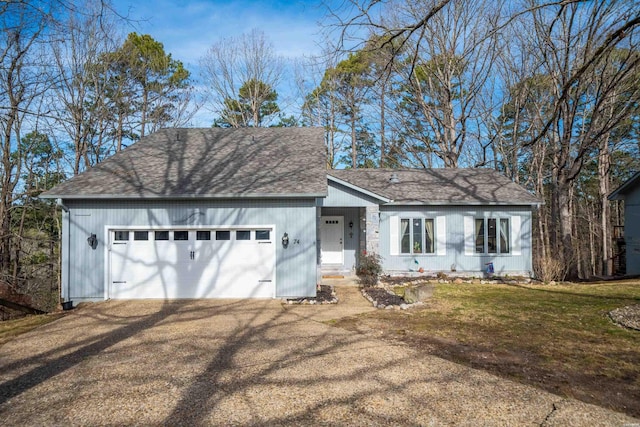 view of front of property with dirt driveway, a front lawn, roof with shingles, and an attached garage