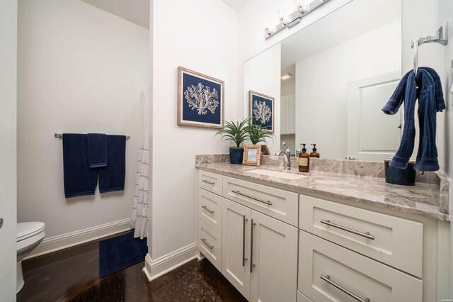 full bath with toilet, wood finished floors, vanity, visible vents, and baseboards