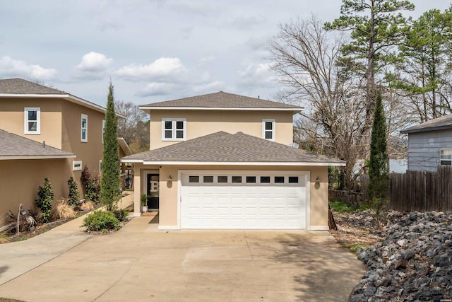 traditional home with roof with shingles, driveway, an attached garage, and stucco siding