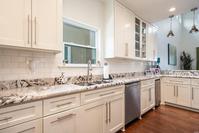 kitchen with glass insert cabinets, white cabinets, a sink, and stainless steel dishwasher