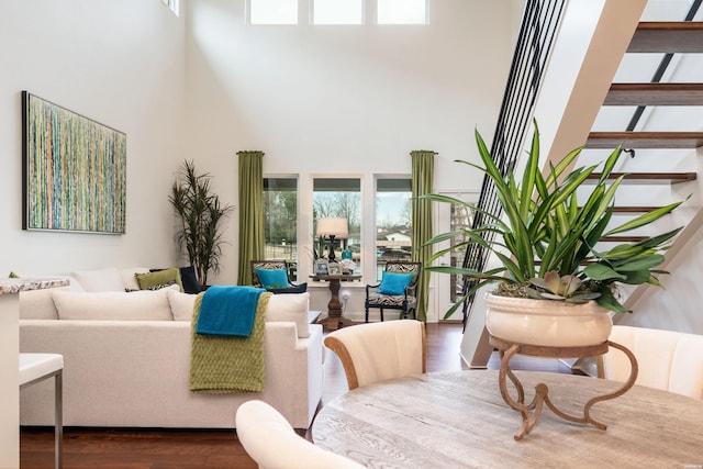 living area featuring a towering ceiling and wood finished floors