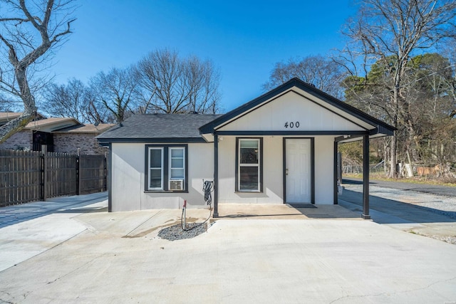 view of front of home with roof with shingles and fence