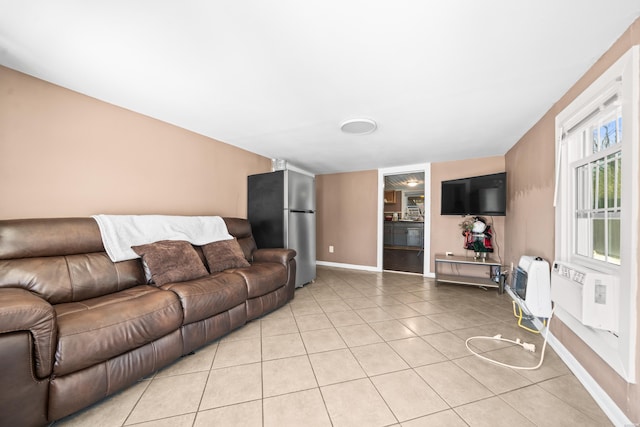 living area with baseboards, light tile patterned flooring, and heating unit