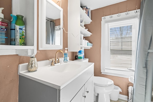 bathroom with plenty of natural light, vanity, and toilet