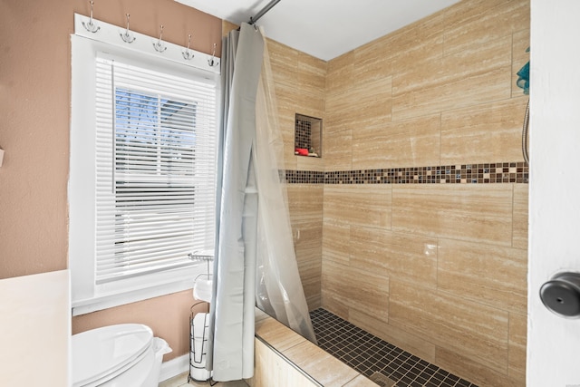 full bath with tiled shower and toilet