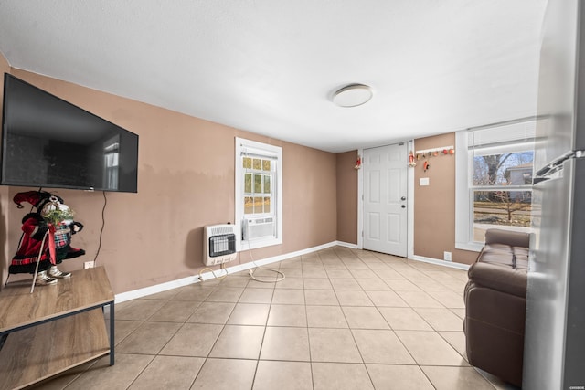 interior space featuring baseboards, light tile patterned flooring, and heating unit