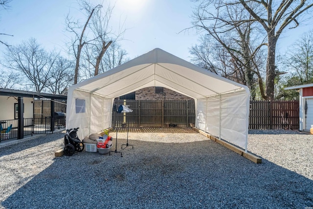 view of outdoor structure with a carport and fence