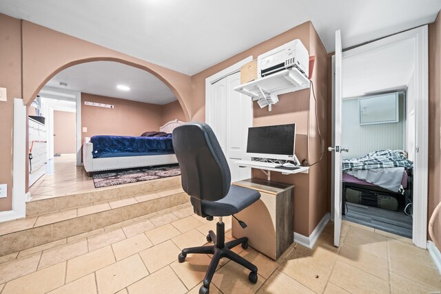 office area with light tile patterned floors and arched walkways