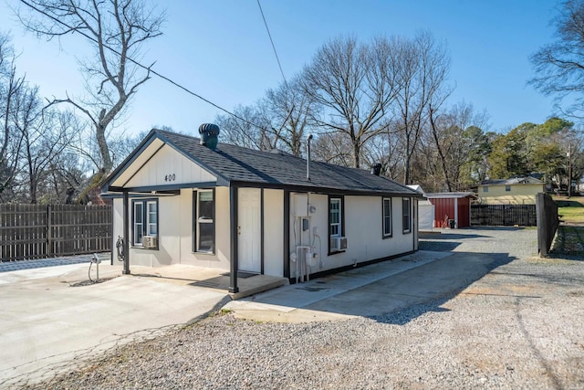 exterior space featuring roof with shingles and fence