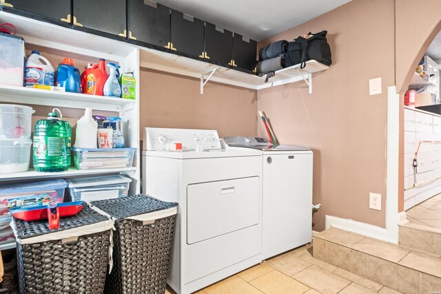 laundry area featuring cabinet space, independent washer and dryer, and light tile patterned floors