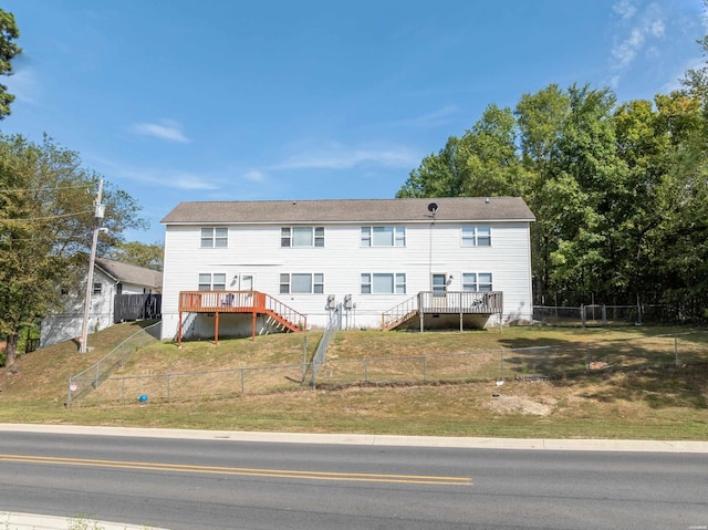 rear view of property with a fenced backyard, stairs, a lawn, and a wooden deck