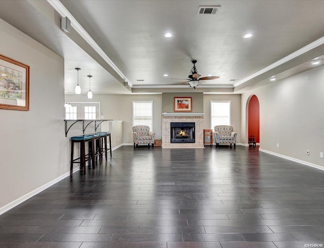 living room with baseboards, visible vents, dark wood finished floors, and a raised ceiling