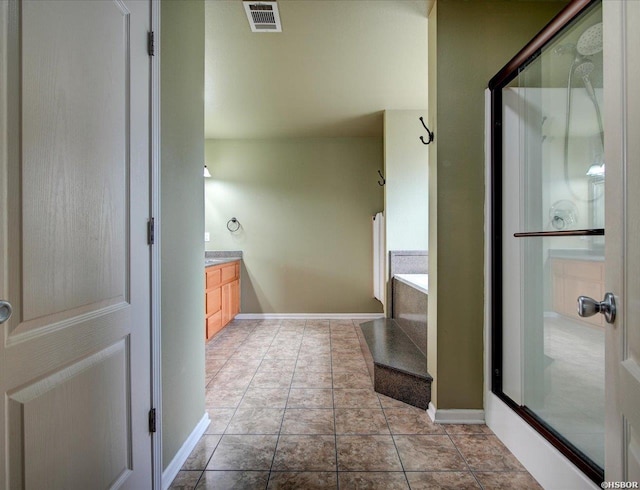 full bath with a stall shower, visible vents, vanity, and tile patterned floors