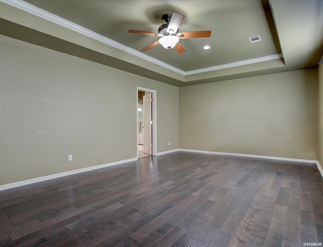 empty room with baseboards, ornamental molding, a raised ceiling, and dark wood-type flooring