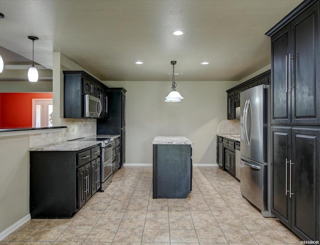 kitchen featuring dark cabinetry, appliances with stainless steel finishes, backsplash, and decorative light fixtures