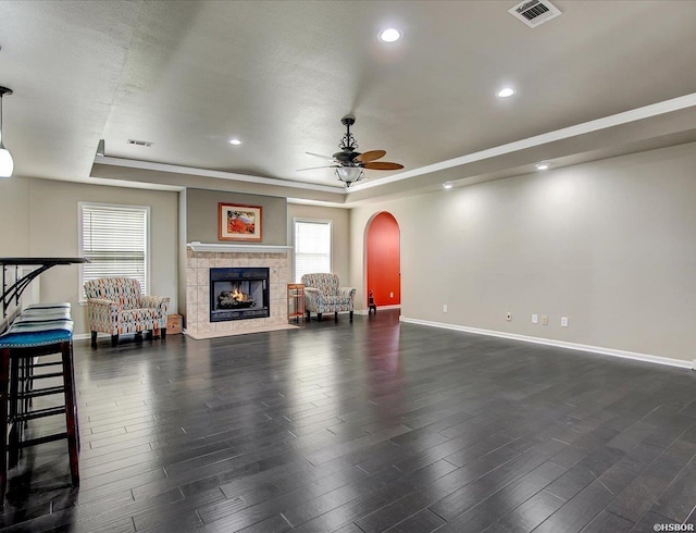 unfurnished living room with dark wood-style floors, a raised ceiling, and visible vents