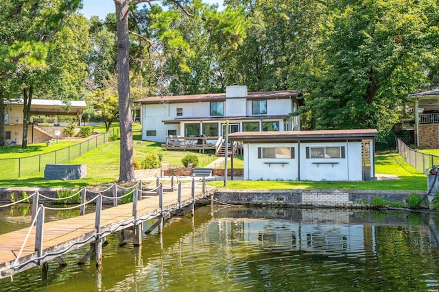 dock area with a deck with water view, a fenced backyard, a lawn, and stairs