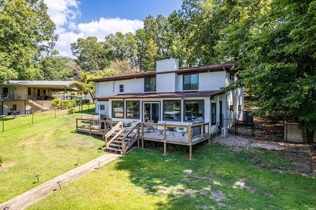 back of property with a wooden deck, a chimney, fence, a yard, and central air condition unit