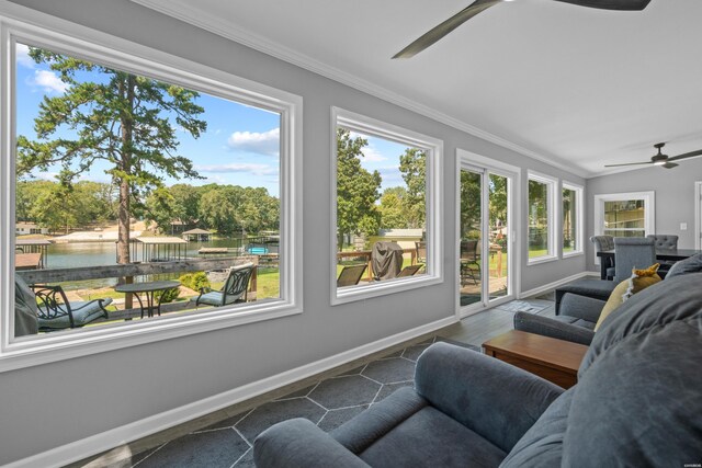 sunroom featuring a water view, ceiling fan, and a wealth of natural light