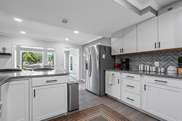 kitchen featuring stainless steel fridge, white cabinetry, crown molding, and visible vents