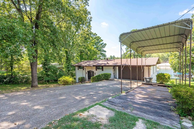 view of front of home featuring driveway, a carport, and stucco siding