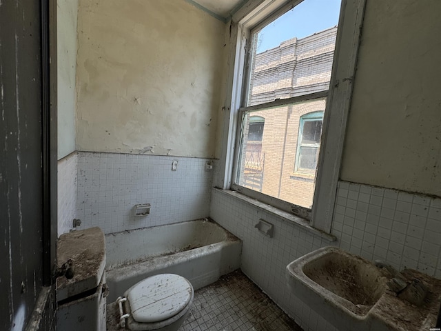 full bath featuring tile patterned floors, a wainscoted wall, tile walls, and a bath