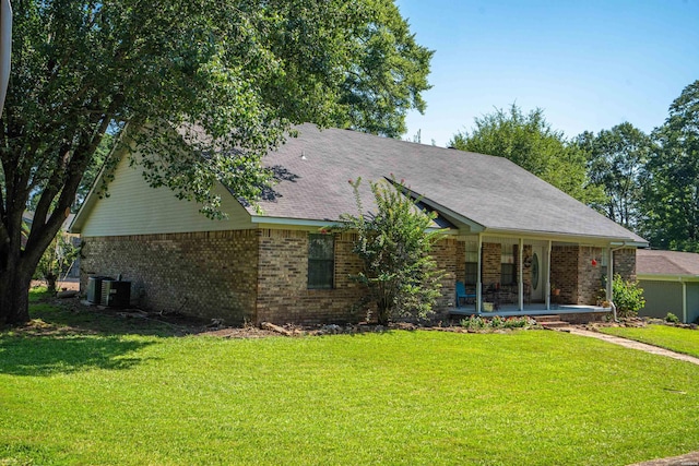 ranch-style home featuring a front lawn, cooling unit, and brick siding